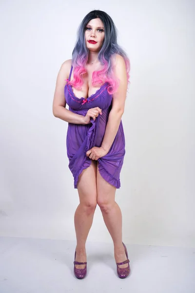 迷人的 Buxom 女孩站在紫色透明睡衣内衣在工作室的白色背景 — 图库照片