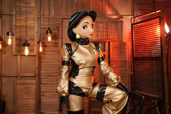 beautiful girl with full face mask doll in leather space jumpsuit posing in her room with light bulbs alone