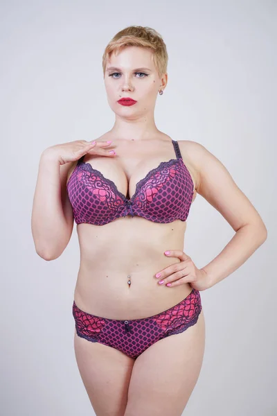 Beautiful young caucasian chubby woman with plus size body and pale skin wearing lace sexy lingerie on white studio background alone