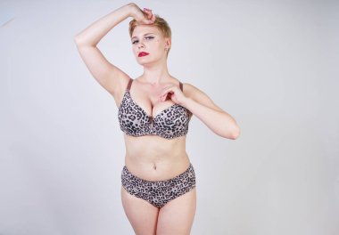 Artı boyutu vücut ve soluk cilt tek başına beyaz stüdyo arka plan leopar baskı ile seksi iç çamaşırı giyen güzel genç kafkas tombul kadın