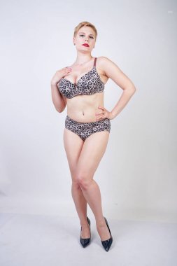 Artı boyutu vücut ve soluk cilt tek başına beyaz stüdyo arka plan leopar baskı ile seksi iç çamaşırı giyen güzel genç kafkas tombul kadın