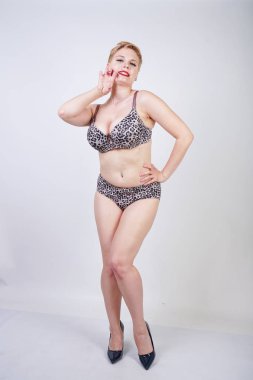 Artı boyutu vücut ve soluk cilt tek başına beyaz stüdyo arka plan leopar baskı ile seksi iç çamaşırı giyen güzel genç kafkas tombul kadın