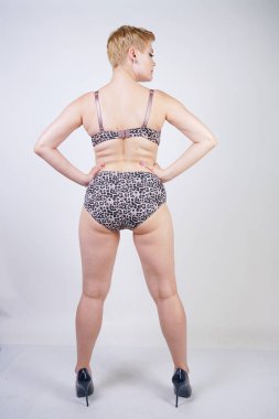 Artı boyutu vücut ve soluk cilt tek başına beyaz stüdyo arka plan leopar baskı ile seksi iç çamaşırı giyen güzel genç kafkas tombul kadın