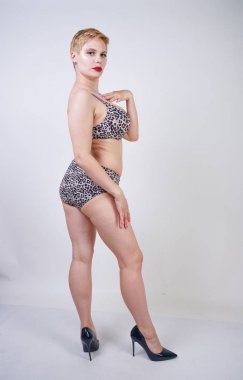 Artı boyutu vücut ve soluk cilt tek başına beyaz stüdyo arka plan leopar baskı ile seksi iç çamaşırı giyen güzel genç kafkas tombul kadın