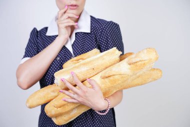 vintage polka nokta elbise giyen ve Studio beyaz bir arka plan üzerinde baget tutan sevimli kafkas pinup kız