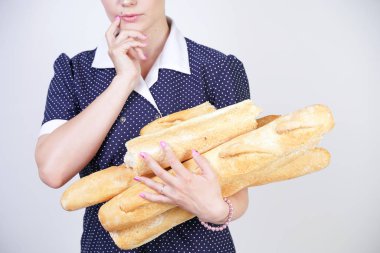 vintage polka nokta elbise giyen ve Studio beyaz bir arka plan üzerinde baget tutan sevimli kafkas pinup kız