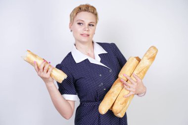 vintage polka nokta elbise giyen ve Studio beyaz bir arka plan üzerinde baget tutan sevimli kafkas pinup kız