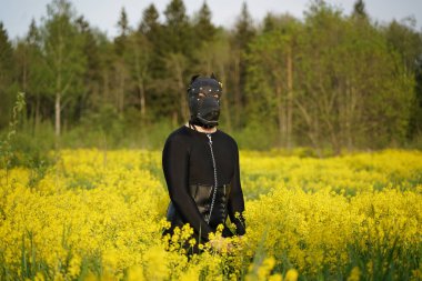 Seksi itaatkar adam spandex siyah catsuit ve deri köpek maskesi giyiyor. Yetişkin kişi petplay yürüyüş ve bdsm oyunu var.