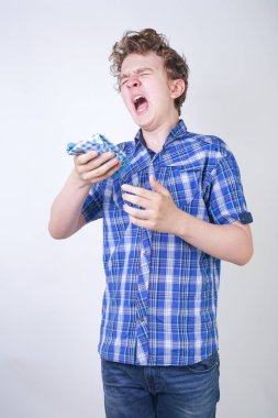 Bir mendil tutan burun akıntısı ile Allergy Boy Çocuk. Genç kötü sağlık yaşıyor ve beyaz stüdyo arka plan tek başına ayakta.