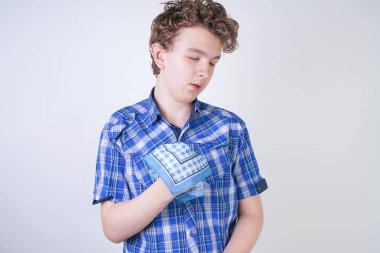 Bir mendil tutan burun akıntısı ile Allergy Boy Çocuk. Genç kötü sağlık yaşıyor ve beyaz stüdyo arka plan tek başına ayakta.