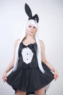 Studio beyaz arka plan tavşan kostümü Bunny kulakları ile uzun beyaz saçlı sevimli kız. artı boyutu vücut ile bir kadın standları ve siyah bir elbise içinde moda pozlar yapmak.