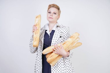 polka noktaları baget ile poz ve Studio beyaz bir arka plan üzerinde onları zevk ile bir bahar ceket kısa saçlı büyüleyici pinup kadın. artı retro giyim ekmek tutan boyutu kız.