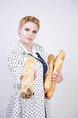 polka noktaları baget ile poz ve Studio beyaz bir arka plan üzerinde onları zevk ile bir bahar ceket kısa saçlı büyüleyici pinup kadın. artı retro giyim ekmek tutan boyutu kız.