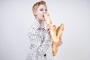 polka noktaları baget ile poz ve Studio beyaz bir arka plan üzerinde onları zevk ile bir bahar ceket kısa saçlı büyüleyici pinup kadın. artı retro giyim ekmek tutan boyutu kız.