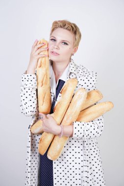 polka noktaları baget ile poz ve Studio beyaz bir arka plan üzerinde onları zevk ile bir bahar ceket kısa saçlı büyüleyici pinup kadın. artı retro giyim ekmek tutan boyutu kız.