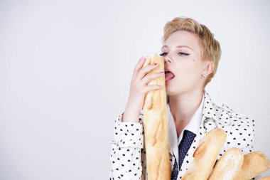 polka noktaları baget ile poz ve Studio beyaz bir arka plan üzerinde onları zevk ile bir bahar ceket kısa saçlı büyüleyici pinup kadın. artı retro giyim ekmek tutan boyutu kız.