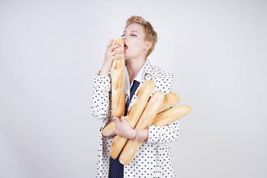 polka noktaları baget ile poz ve Studio beyaz bir arka plan üzerinde onları zevk ile bir bahar ceket kısa saçlı büyüleyici pinup kadın. artı retro giyim ekmek tutan boyutu kız.