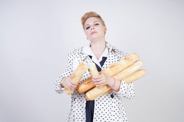 polka noktaları baget ile poz ve Studio beyaz bir arka plan üzerinde onları zevk ile bir bahar ceket kısa saçlı büyüleyici pinup kadın. artı retro giyim ekmek tutan boyutu kız.