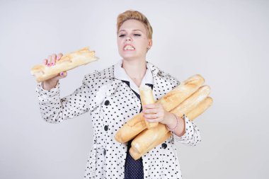 polka noktaları baget ile poz ve Studio beyaz bir arka plan üzerinde onları zevk ile bir bahar ceket kısa saçlı büyüleyici pinup kadın. artı retro giyim ekmek tutan boyutu kız.