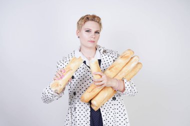 polka noktaları baget ile poz ve Studio beyaz bir arka plan üzerinde onları zevk ile bir bahar ceket kısa saçlı büyüleyici pinup kadın. artı retro giyim ekmek tutan boyutu kız.