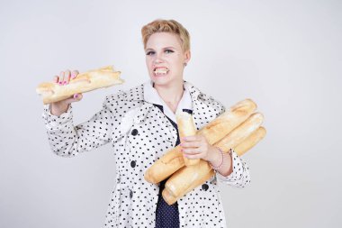 polka noktaları baget ile poz ve Studio beyaz bir arka plan üzerinde onları zevk ile bir bahar ceket kısa saçlı büyüleyici pinup kadın. artı retro giyim ekmek tutan boyutu kız.