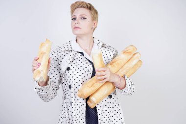 polka noktaları baget ile poz ve Studio beyaz bir arka plan üzerinde onları zevk ile bir bahar ceket kısa saçlı büyüleyici pinup kadın. artı retro giyim ekmek tutan boyutu kız.