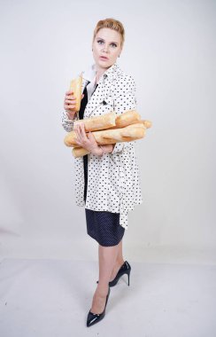 polka noktaları baget ile poz ve Studio beyaz bir arka plan üzerinde onları zevk ile bir bahar ceket kısa saçlı büyüleyici pinup kadın. artı retro giyim ekmek tutan boyutu kız.