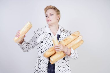 polka noktaları baget ile poz ve Studio beyaz bir arka plan üzerinde onları zevk ile bir bahar ceket kısa saçlı büyüleyici pinup kadın. artı retro giyim ekmek tutan boyutu kız.