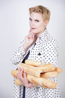 polka noktaları baget ile poz ve Studio beyaz bir arka plan üzerinde onları zevk ile bir bahar ceket kısa saçlı büyüleyici pinup kadın. artı retro giyim ekmek tutan boyutu kız.