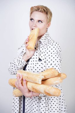 polka noktaları baget ile poz ve Studio beyaz bir arka plan üzerinde onları zevk ile bir bahar ceket kısa saçlı büyüleyici pinup kadın. artı retro giyim ekmek tutan boyutu kız.