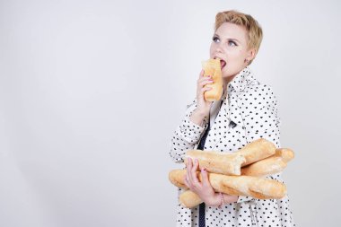 polka noktaları baget ile poz ve Studio beyaz bir arka plan üzerinde onları zevk ile bir bahar ceket kısa saçlı büyüleyici pinup kadın. artı retro giyim ekmek tutan boyutu kız.