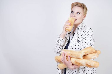 polka noktaları baget ile poz ve Studio beyaz bir arka plan üzerinde onları zevk ile bir bahar ceket kısa saçlı büyüleyici pinup kadın. artı retro giyim ekmek tutan boyutu kız.