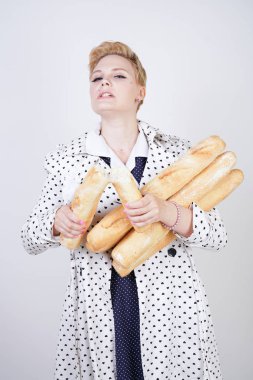 polka noktaları baget ile poz ve Studio beyaz bir arka plan üzerinde onları zevk ile bir bahar ceket kısa saçlı büyüleyici pinup kadın. artı retro giyim ekmek tutan boyutu kız.