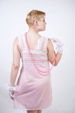 romantik artı boyutu kız kısa sarışın saç pembe dantel gecelik, beyaz ince şeffaf eldiven ve Pearl boncuk stüdyo beyaz arka planda yalnız