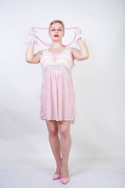 romantik artı boyutu kız kısa sarışın saç pembe dantel gecelik, beyaz ince şeffaf eldiven ve Pearl boncuk stüdyo beyaz arka planda yalnız