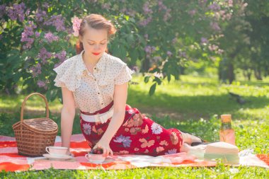 doğaya dinlenmiş olan kız oldukça genç pin. tartan ekose oturan vintage elbise giyen mutlu ince genç kadın ve yalnız yaz günü rahatlatıcı.