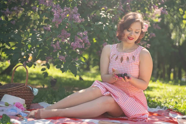 魅力的なピンナップの女の子は 緑の夏の草の上に休息とピクニックを楽しんでいます かなりヴィンテージスタイルの白人女性は 単独で都市公園に空き地を過ごす — ストック写真