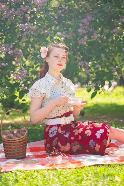 doğaya dinlenmiş olan kız oldukça genç pin. tartan ekose oturan vintage elbise giyen mutlu ince genç kadın ve yalnız yaz günü rahatlatıcı.