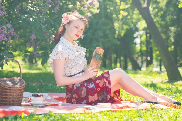 自然の上で休んでいるかわいい若いピンアップ女の子 タータンチェックの上に座って 夏の日だけでリラックスしてヴィンテージドレスを着て幸せなスリムな若い女性 — ストック写真