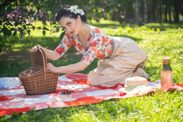 魅力的なブルネットの若い女の子は 一人で緑の夏の草の上に休息とピクニックを楽しんでいます かわいい女性は休日を持っており 自然に空き地を過ごす — ストック写真