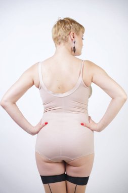 tek başına beyaz stüdyo arka plan üzerinde dikiş ile bej vintage bodysuit ve seksi klasik çorap poz kıvrımlı vücut ile güzel sarı kısa saç retro kadın. artı moda iç çamaşırı boyutu yetişkin kız.