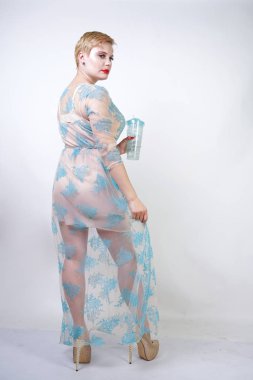 kısa saçlı ve artı boyutu vücut uzun şeffaf mavi dantel elbise giyen oldukça sevimli sarışın kadın. beyaz stüdyo arka plan tek başına sevimli gecelik şık şık yetişkin kız.