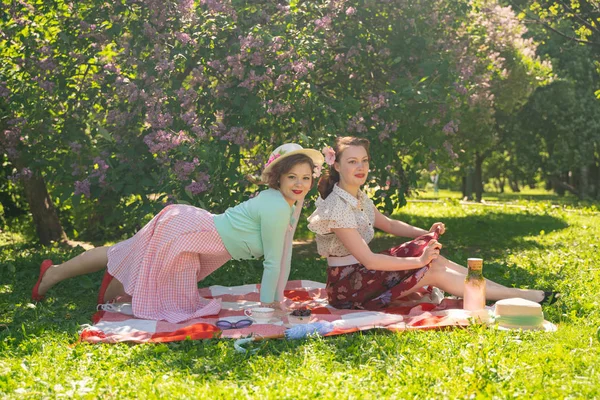 Zwei Hübsche Freundinnen Sitzen Auf Der Roten Decke Grünen Gras — Stockfoto