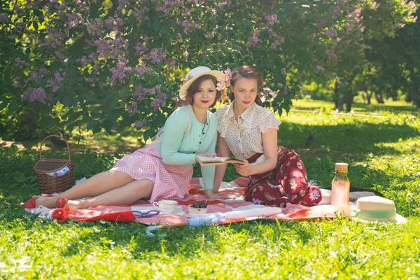 Duas Meninas Bonitas Amigos Sentados Cobertor Vermelho Grama Verde Fazer — Fotografia de Stock