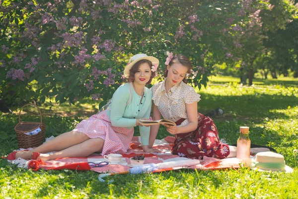 Duas Meninas Bonitas Amigos Sentados Cobertor Vermelho Grama Verde Fazer — Fotografia de Stock