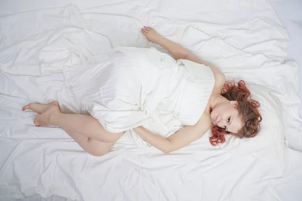 Bela Jovem Está Deitada Uma Cama Branca Desfrutando Manhã Encantadora — Fotografia de Stock