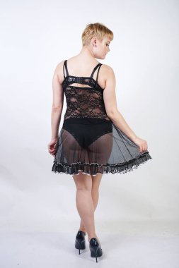 Siyah ve beyaz dantel iç çamaşırı elbise giyen ve stüdyo arka planda poz tombul rakam ile Pretty kısa sarı saç genç kadın. artı boyutu vücut tek başına ayakta seksi vintage yetişkin kız. 