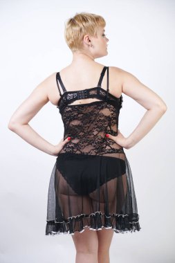 Siyah ve beyaz dantel iç çamaşırı elbise giyen ve stüdyo arka planda poz tombul rakam ile Pretty kısa sarı saç genç kadın. artı boyutu vücut tek başına ayakta seksi vintage yetişkin kız. 