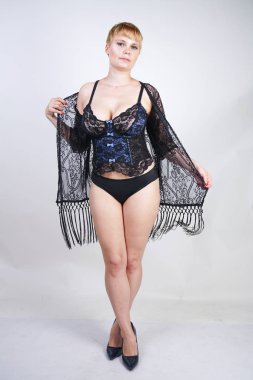 seksi artı mavi ve siyah dantel korse iç çamaşırı kısa saçlı boyutu kadın yalnız. beyaz stüdyo arka planda şık iç çamaşırı poz sıcak sarışın yetişkin kız.