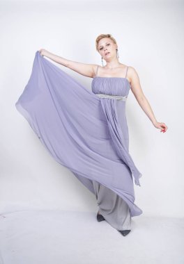 gri uzun elbise zarif kalın kadın. beyaz stüdyo arka plan üzerinde duran gece elbisesi güzel artı boyutu kadın. gri giysiler içinde kısa saç tombul kız tek başına poz.